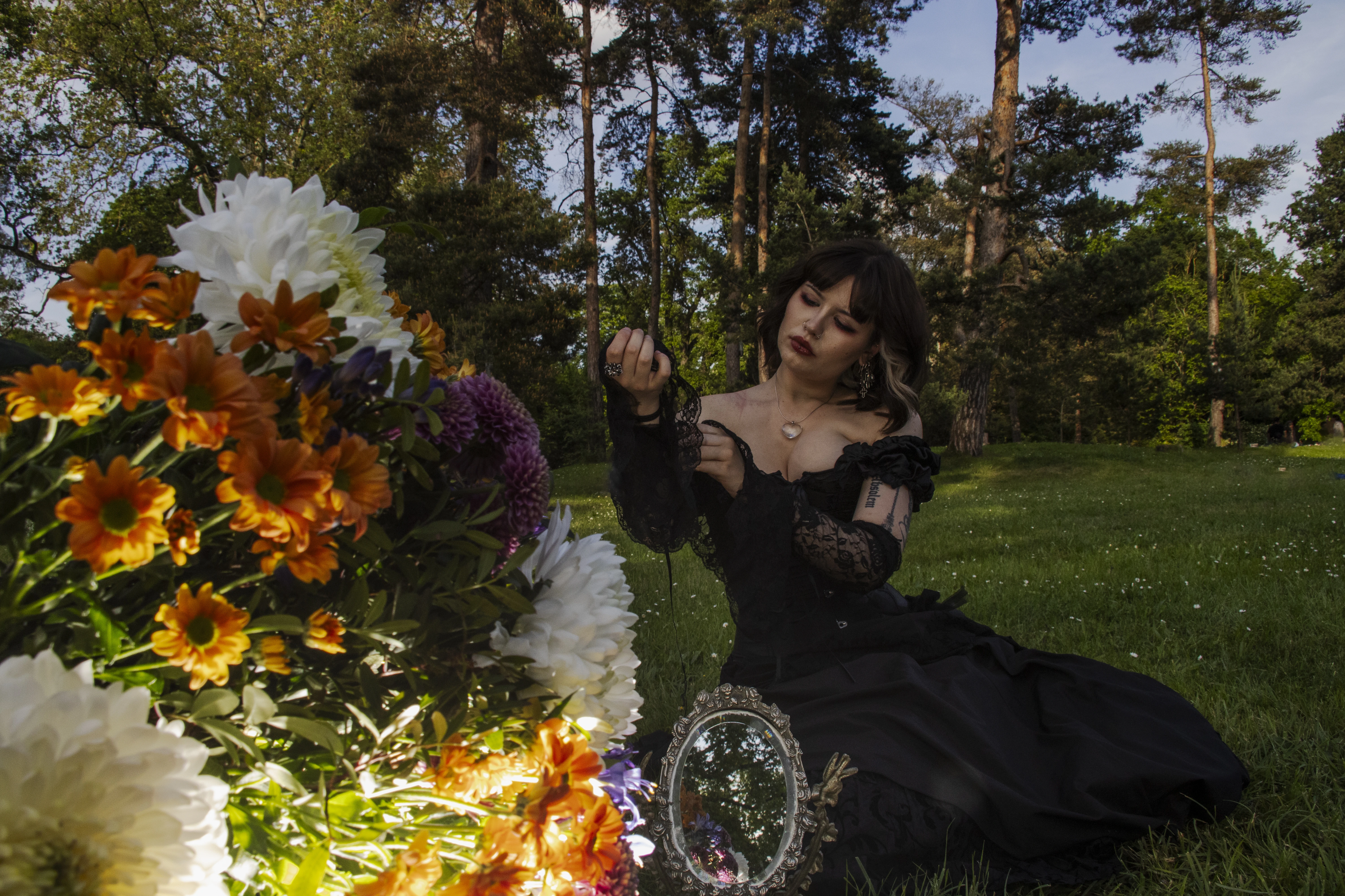 Shooting photo extérieur en Essonne - modèle féminin en robe noire dans un parc naturel avec bouquet